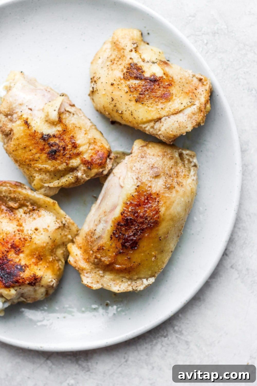 Perfectly cooked crispy sous vide chicken thighs on a plate with fresh herbs