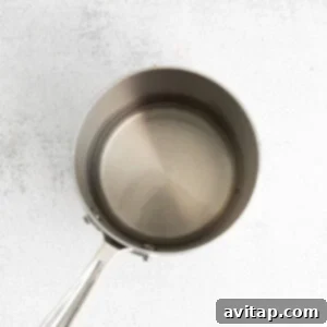 A stainless steel frying pan with honey simple syrup simmering.