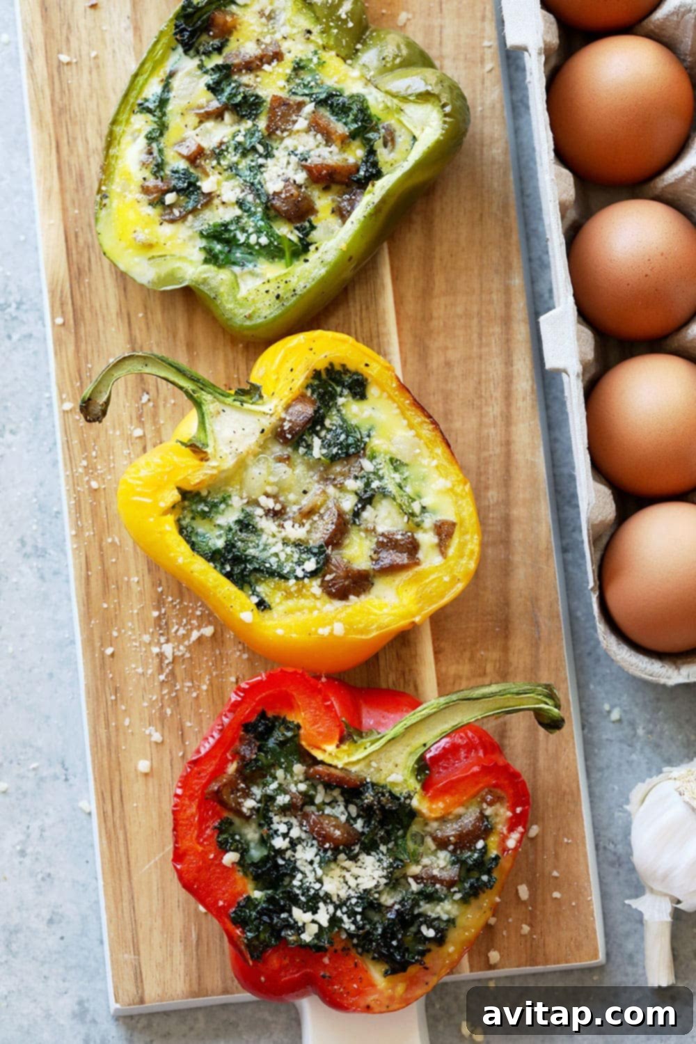 Delicious cheesy breakfast sausage stuffed peppers on a rustic cutting board, garnished with fresh herbs, ready to be served for a wholesome morning meal.