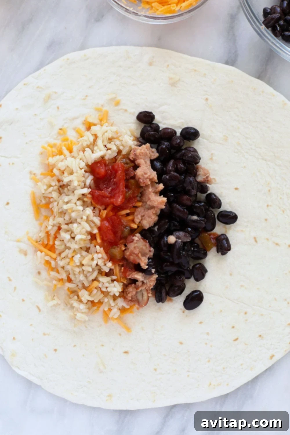 Simple 6-Ingredient Bean Burritos 4 Close-up of bean burrito ingredients (rice, beans, cheese, salsa) being assembled on a flour tortilla.