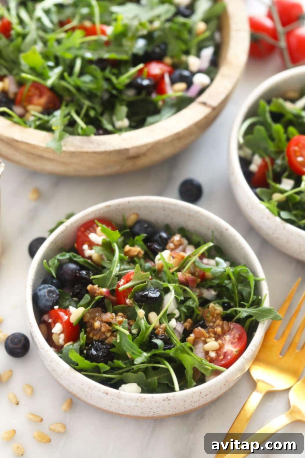 Arugula salad served in a small, elegant bowl, garnished with fresh herbs.