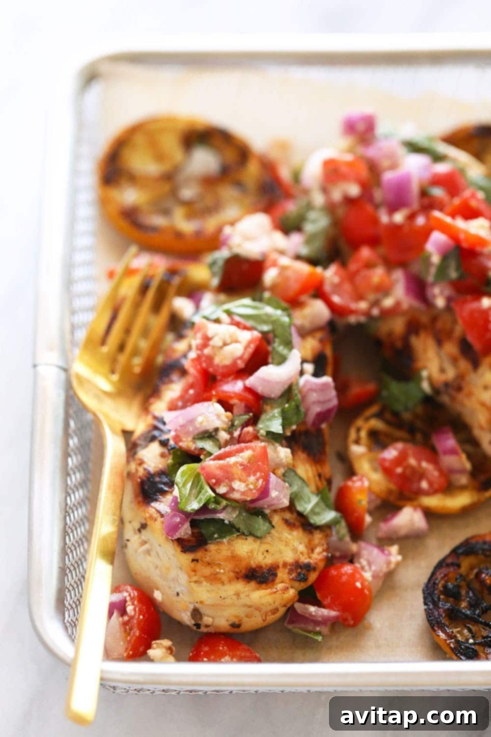 Zesty Grilled Greek Chicken 2 Lemon Greek chicken with fresh tomatoes on top.