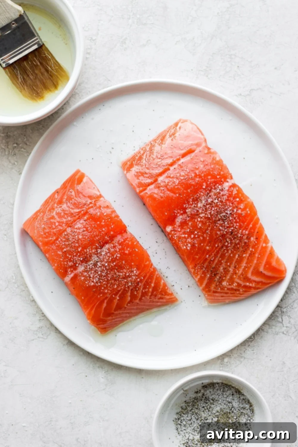 Zesty Salmon Power Bowls 4 raw salmon filets being brushed with olive oil