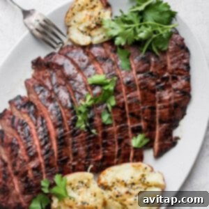 Grilled flank steak on a plate, ready to be enjoyed.