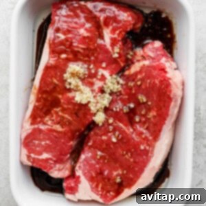 Chargrilled Flank Steak 2 Steak marinating in a casserole dish, ready for grilling.