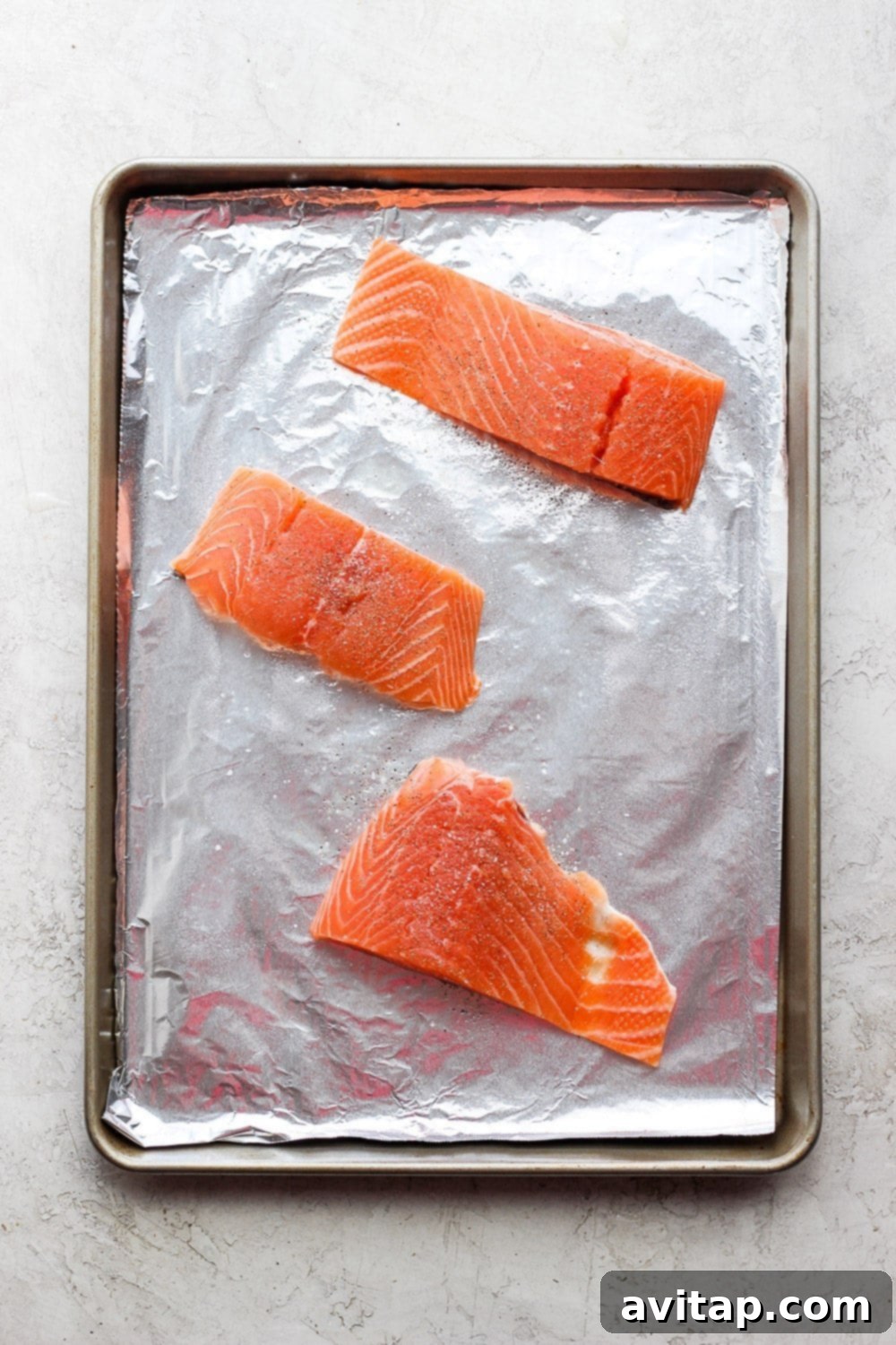 Salmon fillets on a sheet pan ready to be broiled