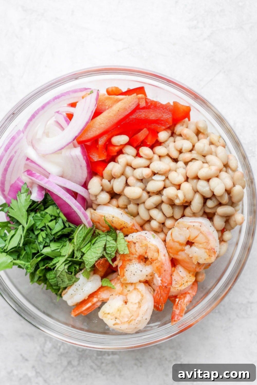 All the vibrant, fresh ingredients for a healthy shrimp salad assembled in a large bowl before mixing