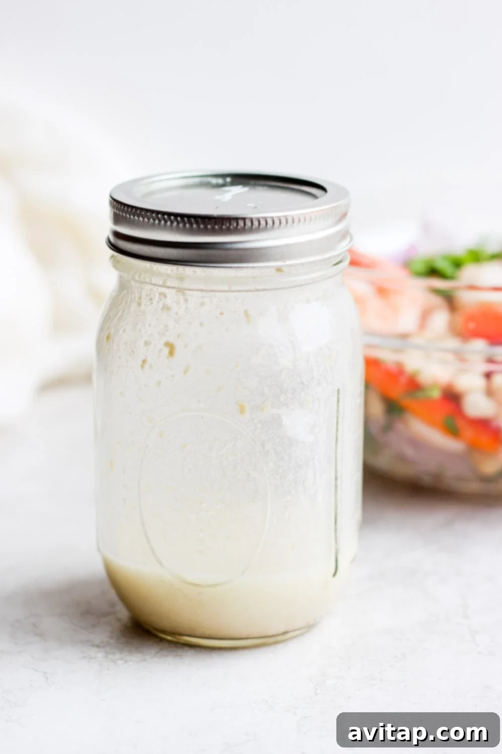 A creamy, mayo-free dressing specifically made for healthy shrimp salad, presented in a jar