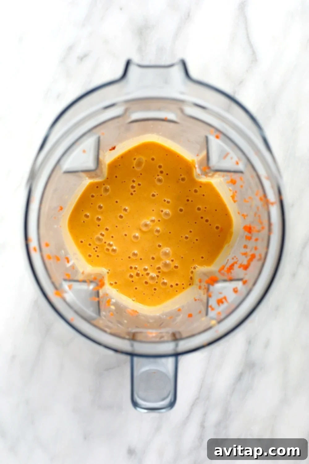 A carrot cake smoothie being blended to perfection in a high-speed Vitamix blender, demonstrating the creamy texture.