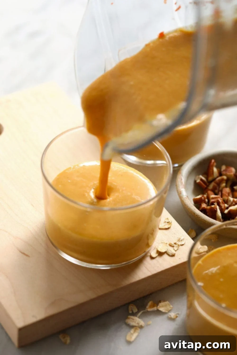 Smoothie being poured into a glass, showcasing its rich and creamy consistency.