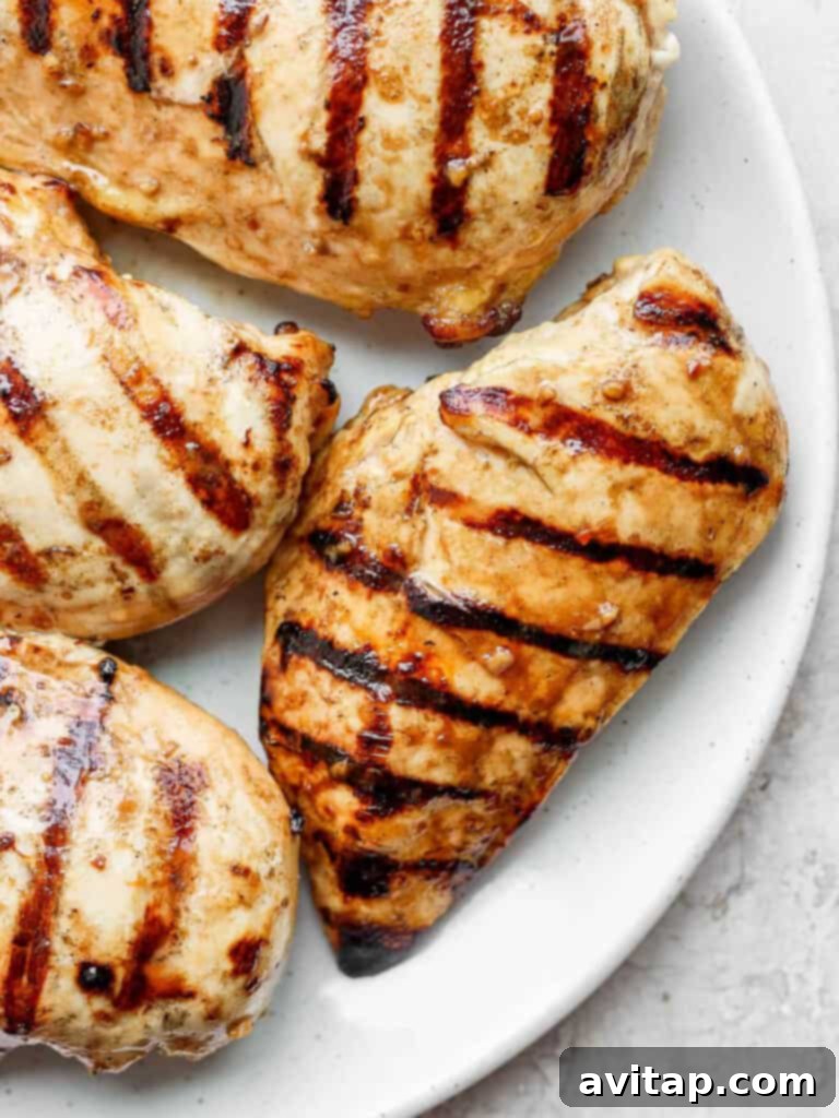 Succulent Grilled Chicken 2 Perfectly grilled chicken breast on a white plate, ready to be served, showcasing beautiful grill marks and a succulent appearance.