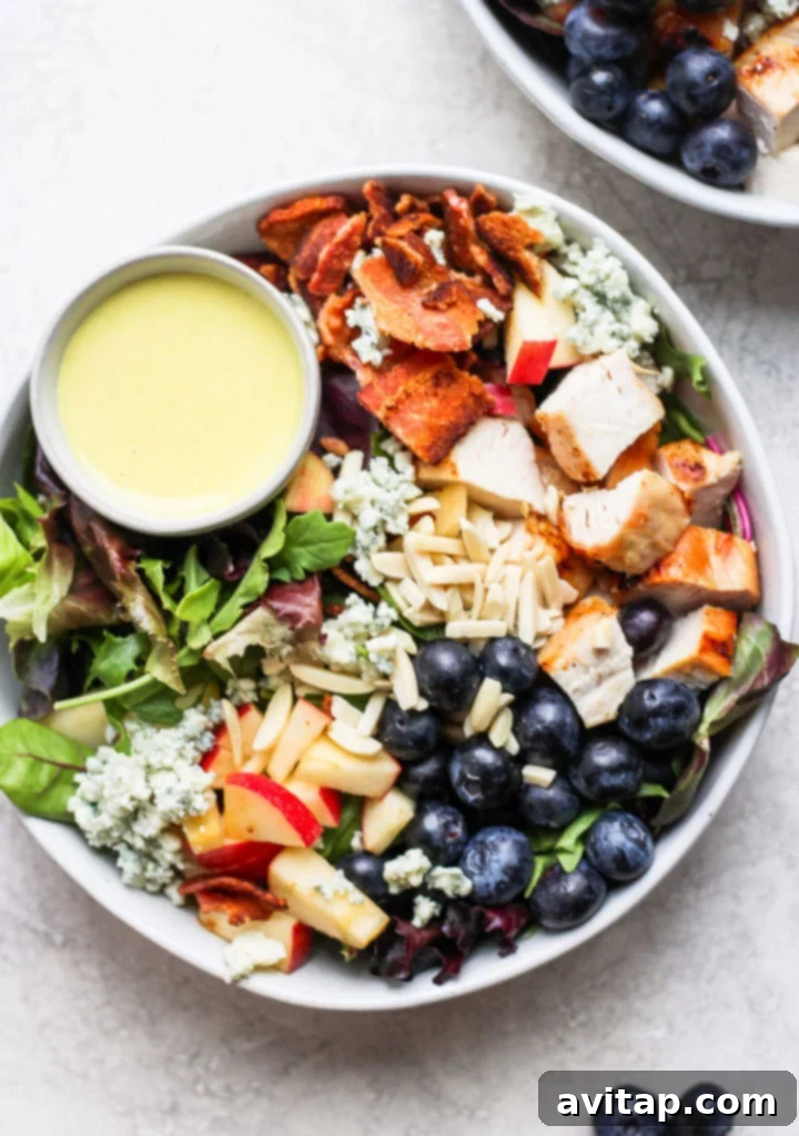 Succulent Grilled Chicken 9 A vibrant grilled chicken salad in a large bowl with dressing, featuring fresh greens and colorful toppings.