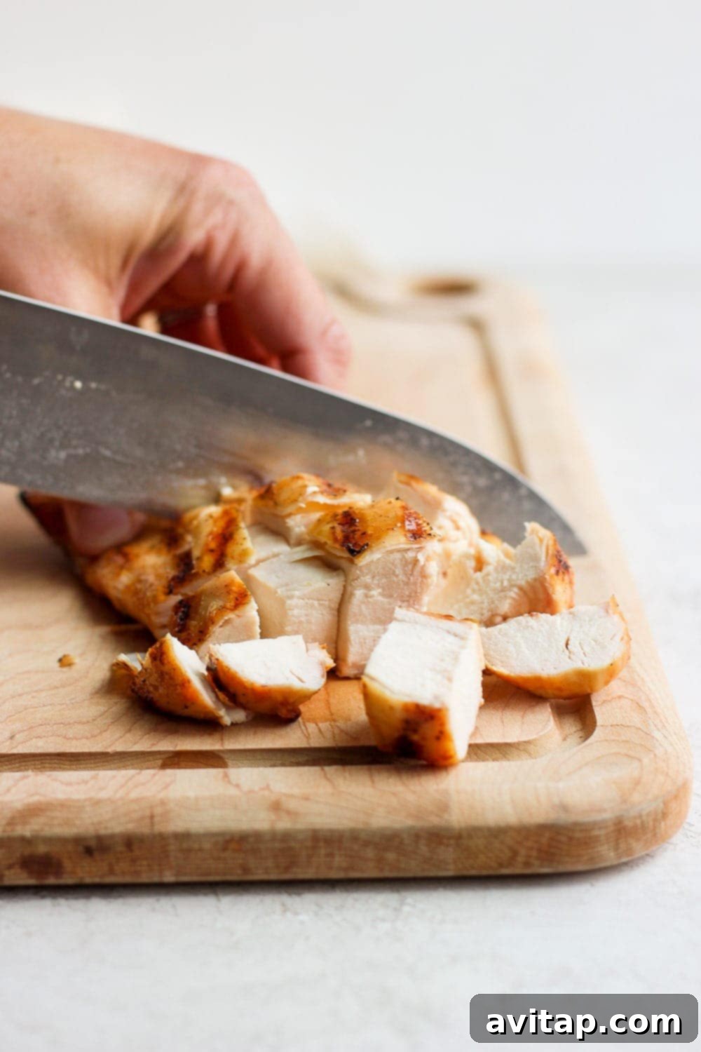 Let your chicken breast rest for at least 5-10 minutes to make sure that the continue to fully cook. Bonus- as the chicken rests, it becomes ultra juicy and tender! Slices of perfectly grilled chicken breast on a cutting board, demonstrating its juicy interior.