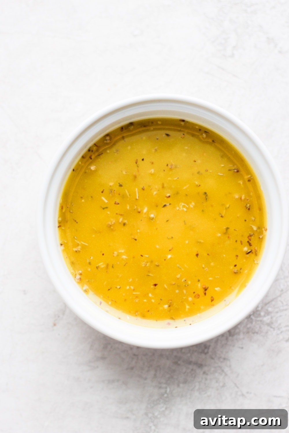 Effortlessly Delicious Greek Chicken Marinade 5 Greek chicken marinade being mixed in a bowl with fresh ingredients