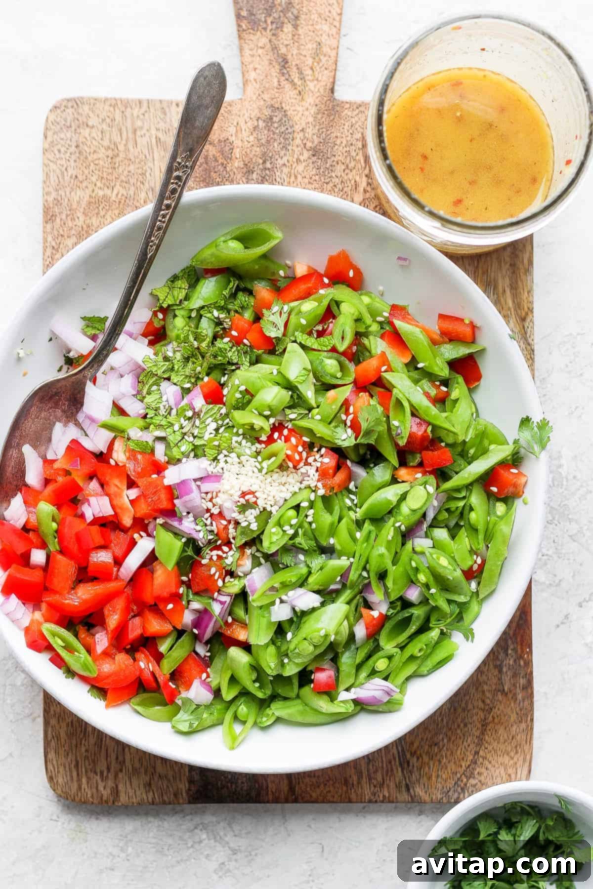 Zesty Ginger Pea Salad 2 A large bowl filled with vibrant ginger pea salad, showcasing the fresh sugar snap peas, red bell peppers, and herbs.