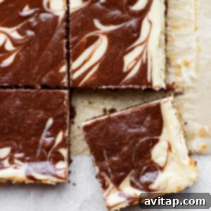 A beautifully swirled slice of chocolate chai Greek yogurt cheesecake bar on a piece of parchment paper, ready to be enjoyed.