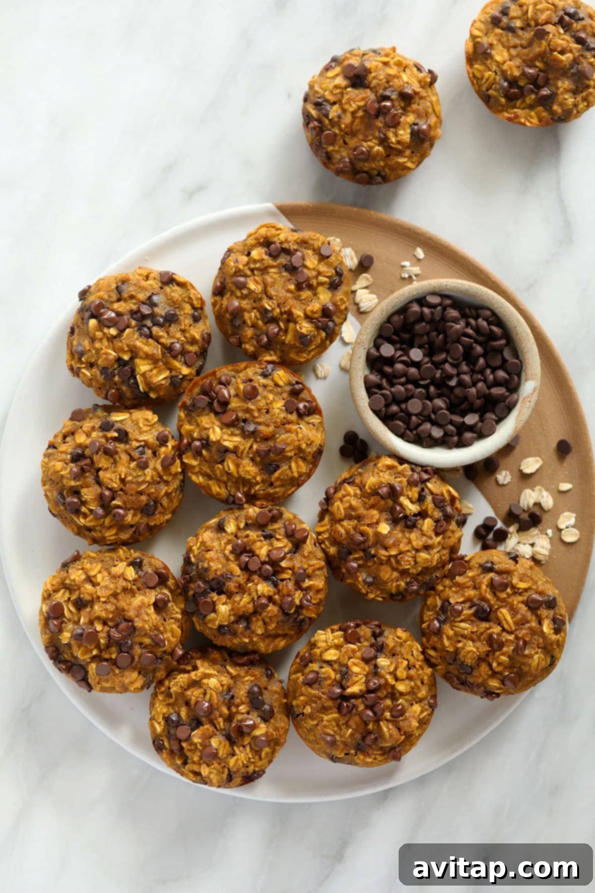 Pumpkin Spice Oatmeal Cups 4 Stacked pumpkin oatmeal cups on a round plate, showcasing their perfect muffin shape and appealing texture.