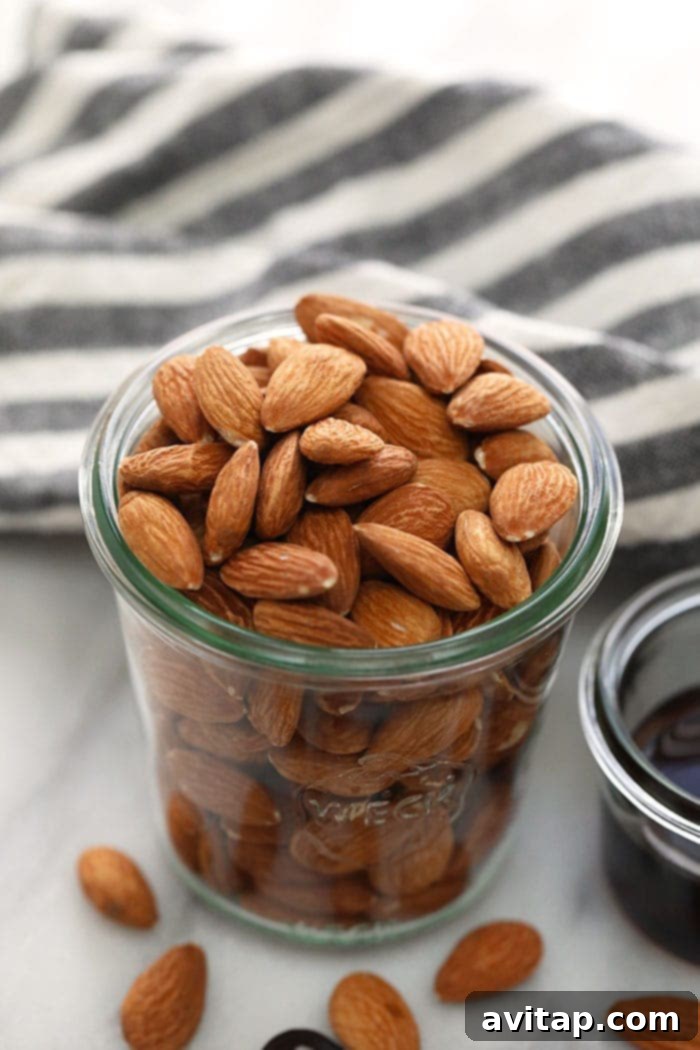Raw almonds in a glass jar, ready for roasting to make homemade almond butter.