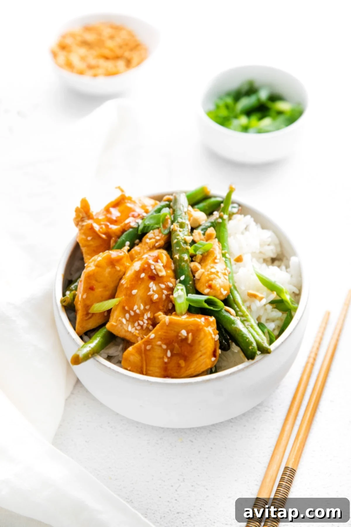 Delicious & Healthy Kung Pao Chicken, ready to eat A close-up of a bowl filled with freshly cooked Kung Pao Chicken, garnished with sesame seeds and green onions.