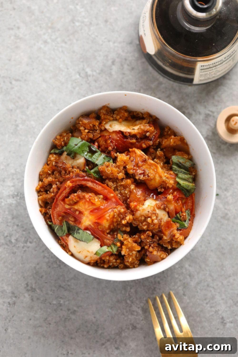 A serving of Tuscan chicken quinoa casserole in a white bowl, ready to eat
