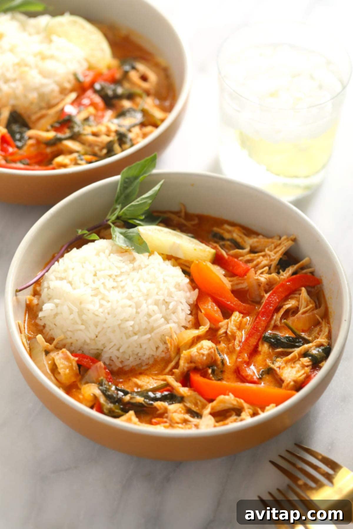 A tempting bowl of coconut curry with a fork, ready to be enjoyed, showcasing the rich texture and vibrant colors.