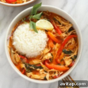 coconut curry chicken in bowl with rice and basil