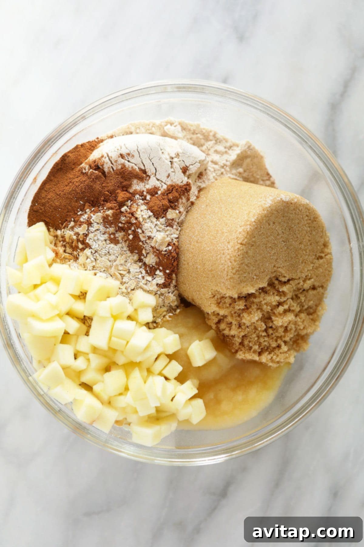 All the dry and wet ingredients for apple oatmeal cookies neatly arranged in separate bowls.