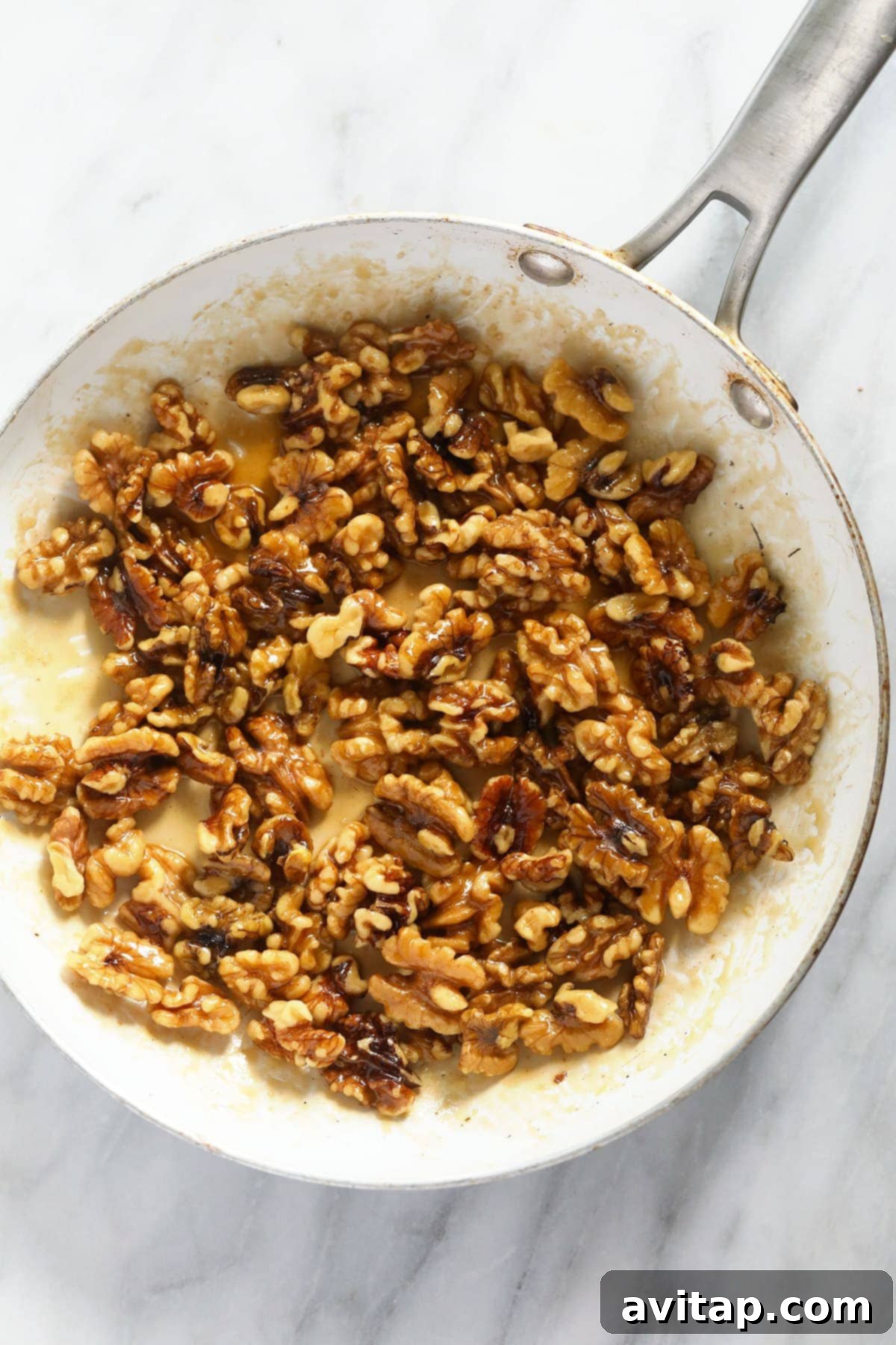 Simply Delicious Candied Walnuts 4 Candied walnuts simmering in a pan on the stovetop, coated in a sweet, sticky glaze.