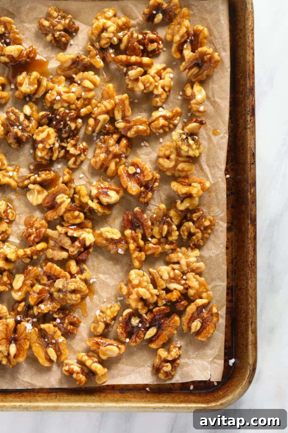 Simply Delicious Candied Walnuts 5 A close-up of candied walnuts sprinkled with coarse sea salt, showcasing their sweet and savory appeal.
