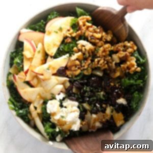 A Thanksgiving salad featuring kale, apples, and walnuts, presented in a rustic bowl.