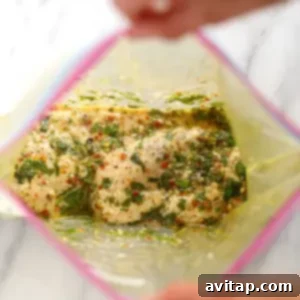 Chicken breasts marinating in a plastic bag with Italian dressing.