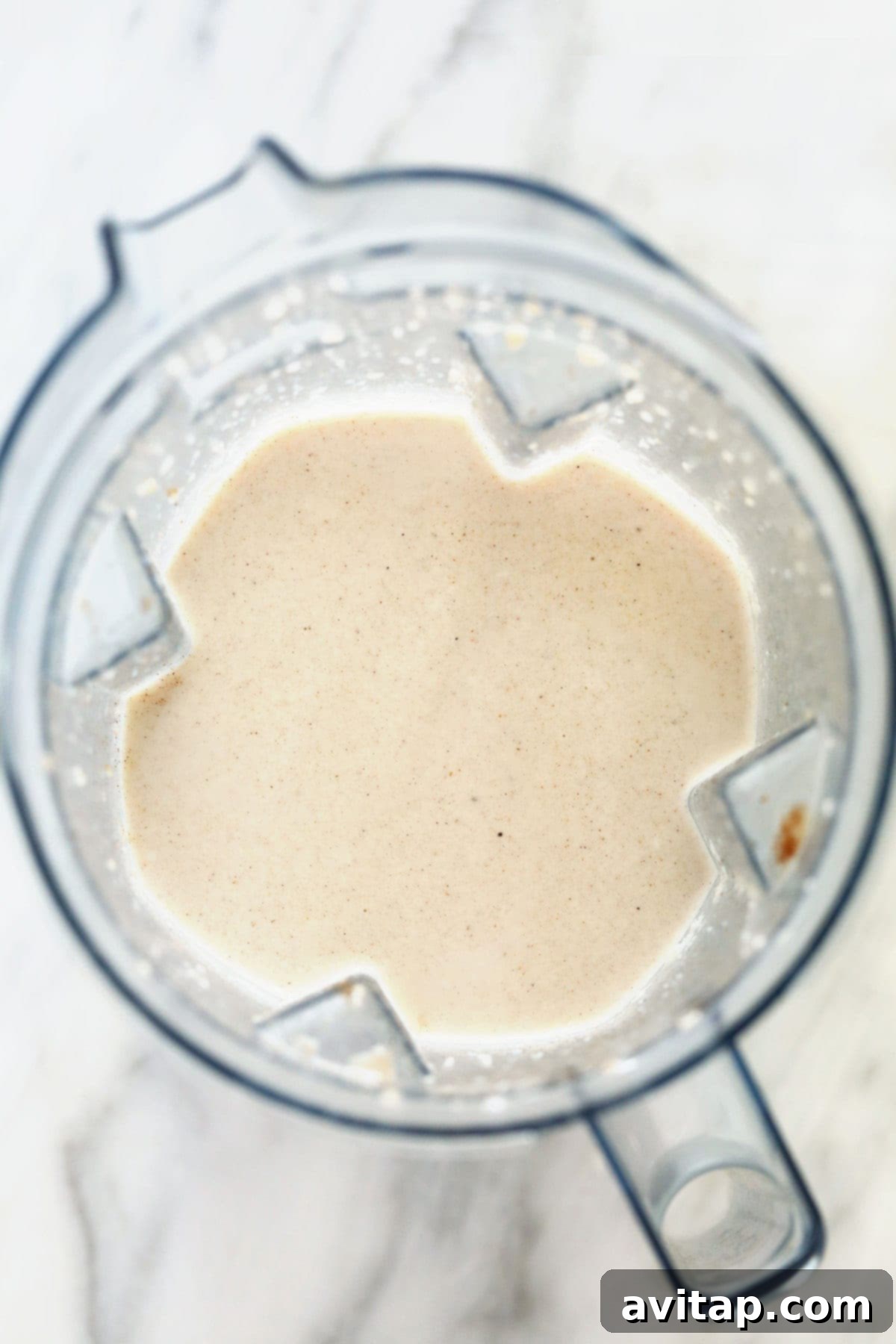 A perfectly blended chai protein shake swirled in a high-speed blender.