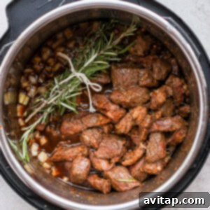 Instant pot beef stew infused with aromatic rosemary sprigs.