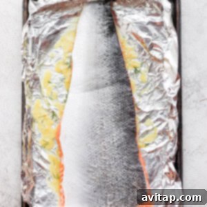 Salmon marinating on foil in a baking sheet