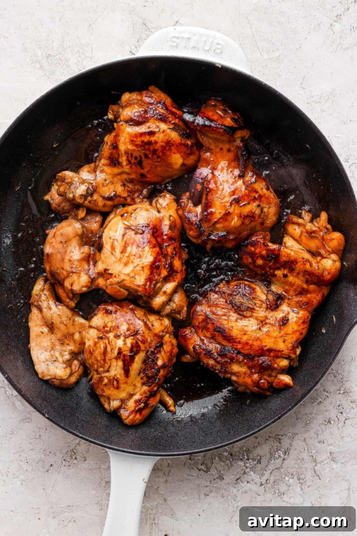 Perfectly grilled balsamic chicken served in a skillet on a clean white background.