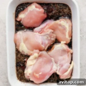 Raw chicken breasts in a white baking dish, ready for marinating.