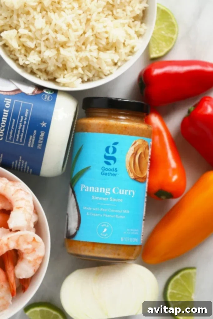 Quick and Creamy Panang Shrimp 3 Good & Gather Panang curry simmer sauce, coconut oil, mini sweet peppers, and shrimp arranged on a cutting board, ready for preparation.