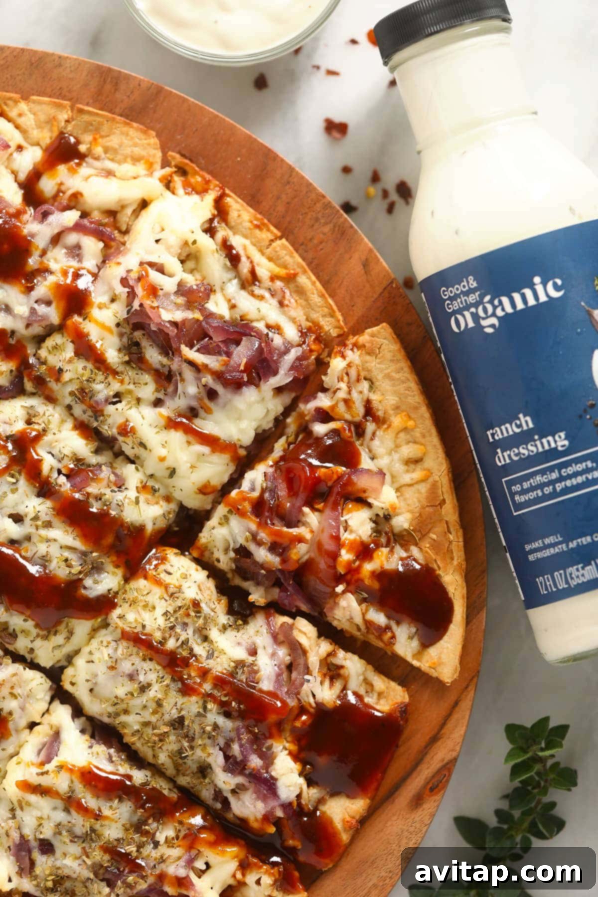 Sweet & Smoky BBQ Chicken Pizza 2 Delicious BBQ chicken pizza with caramelized onions on a wooden cutting board, ready to be served.