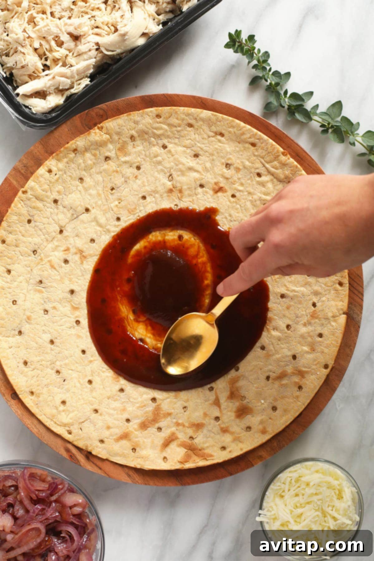 Sweet & Smoky BBQ Chicken Pizza 4 Spreading savory BBQ sauce evenly onto a thin pizza crust, preparing the base for a flavorful BBQ chicken pizza.