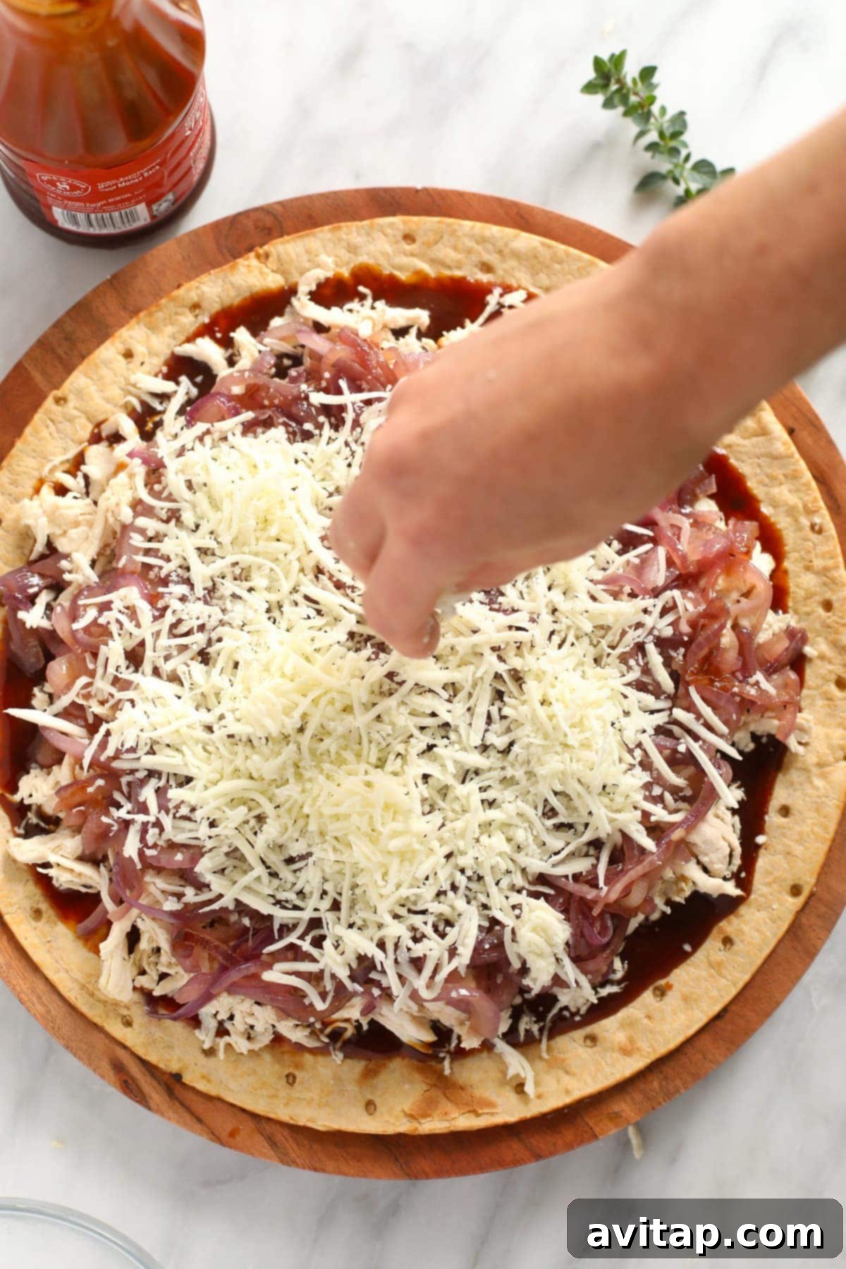 Sweet & Smoky BBQ Chicken Pizza 5 Sprinkling shredded mozzarella cheese generously over the BBQ chicken pizza, before it goes into the oven.