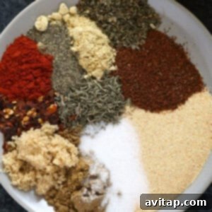 A small plate showcasing a blend of colorful spices, the all-purpose chicken seasoning, ready to be used.