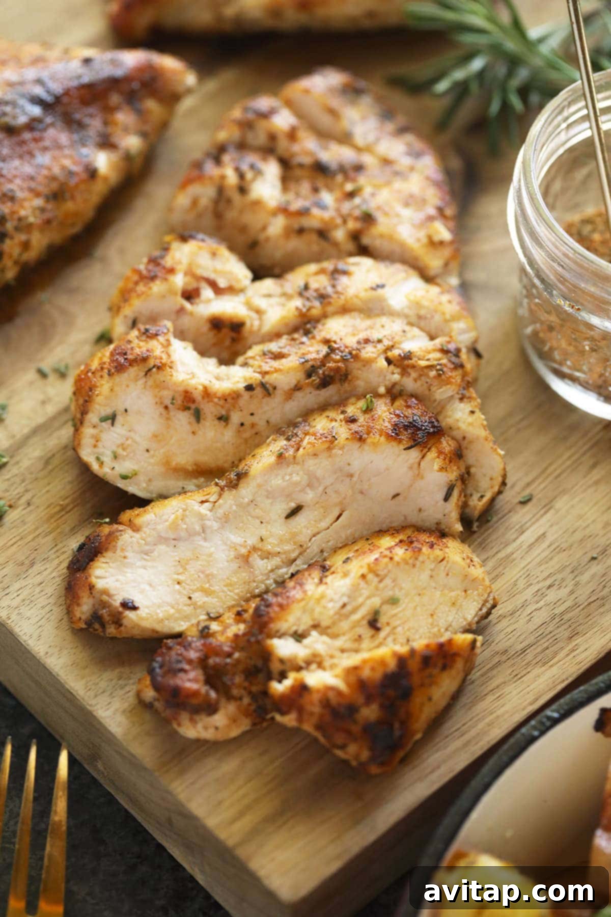 Pan Seared Chicken Breast is an easy weeknight meal that takes less than 30 minutes to whip up and only a few ingredients. Sliced, juicy pan-seared chicken breast on a wooden cutting board, ready to be served, emphasizing its tender texture.
