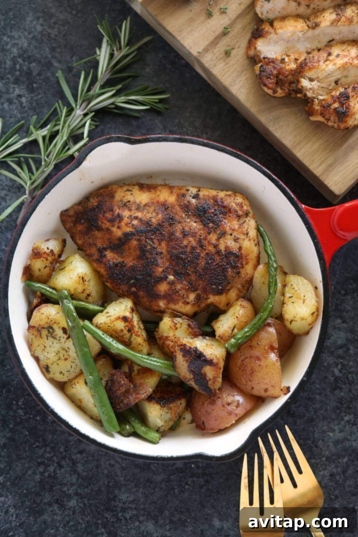Make this flavorful stovetop chicken breast recipe and pair it with your favorite veggie and grain to complete your meal! A delicious pan-seared chicken breast dinner, served with roasted potatoes and green vegetables in a rustic pan, highlighting a complete meal.