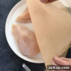 A person slicing a piece of chicken on a plate, demonstrating the final cooked texture.