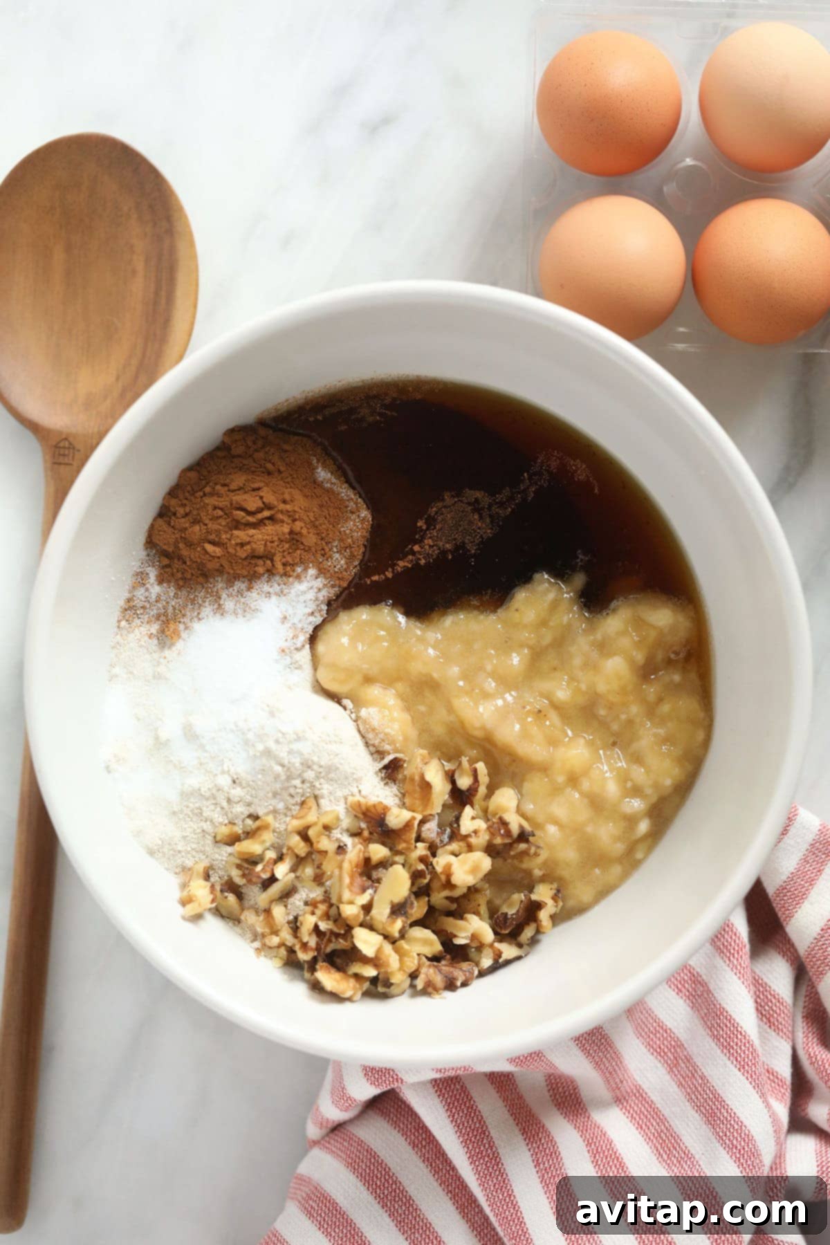 All the dry and wet ingredients for the banana nut muffins are neatly separated and arranged in bowls, ready to be combined into a cohesive, delicious mixture.