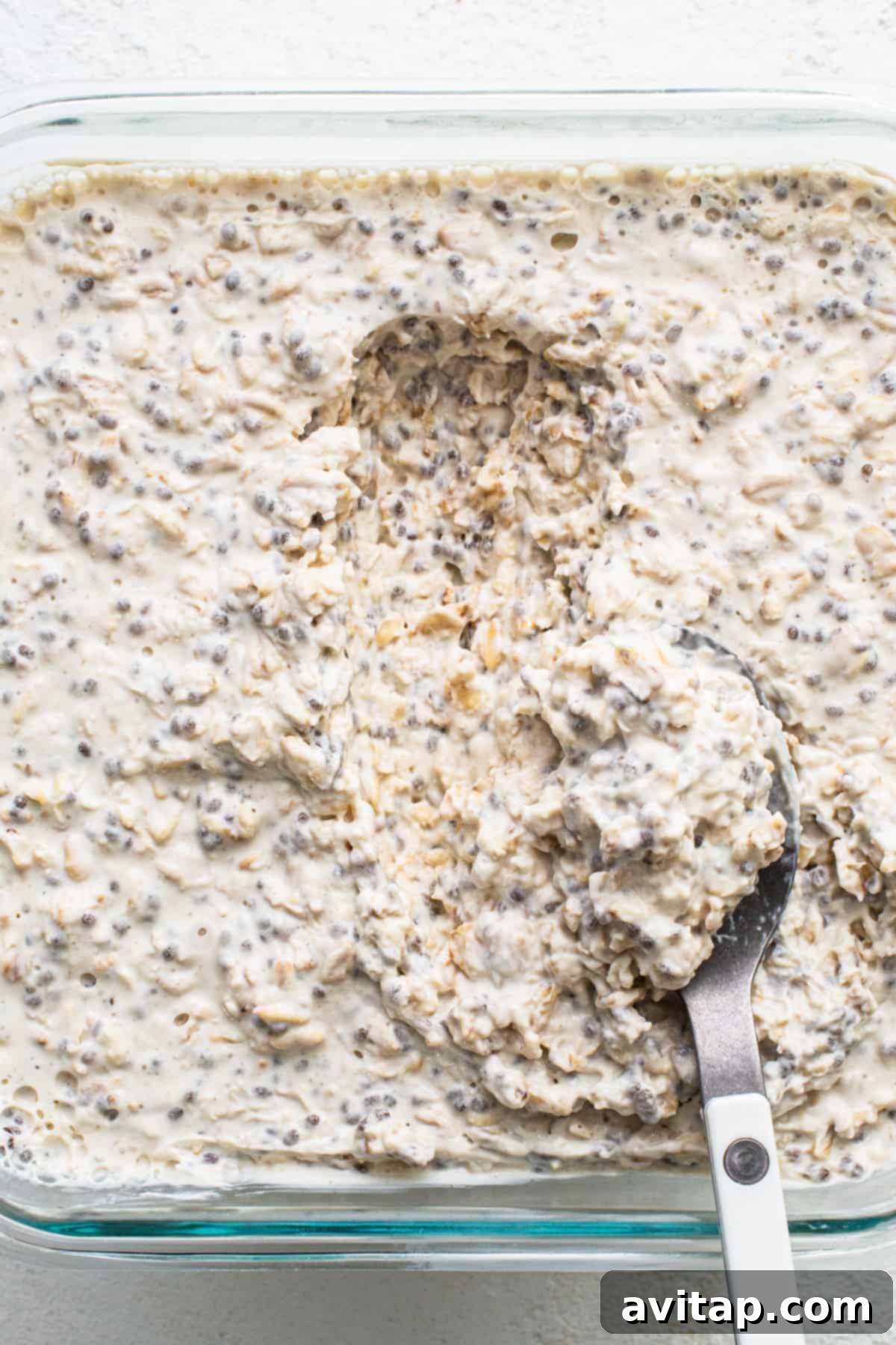 A simple bowl of overnight oats with a spoon resting in it, ready to be enjoyed.