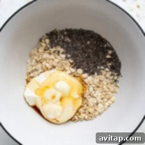 A bowl of oatmeal, oats and a dollop of whipped cream, representing the mixing step.
