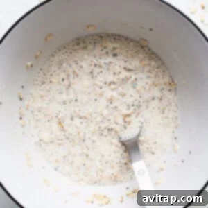Oats in a bowl with a spoon, showing the mixture after adding variation ingredients.