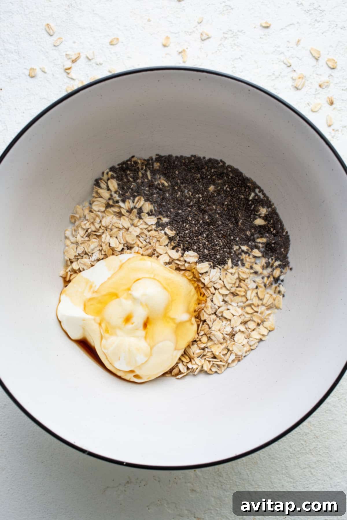 A close-up of a perfectly prepared bowl of overnight oats, topped with a dollop of whipped cream and a sprinkle of cinnamon, highlighting its creamy texture.