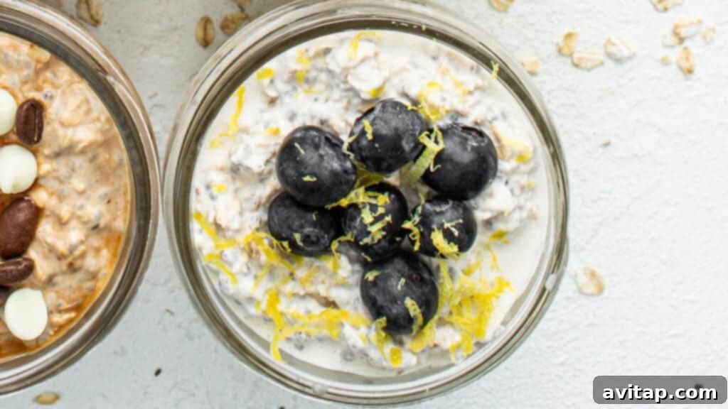 Three jars of lemon blueberry overnight oats, garnished with fresh blueberries and lemon slices.